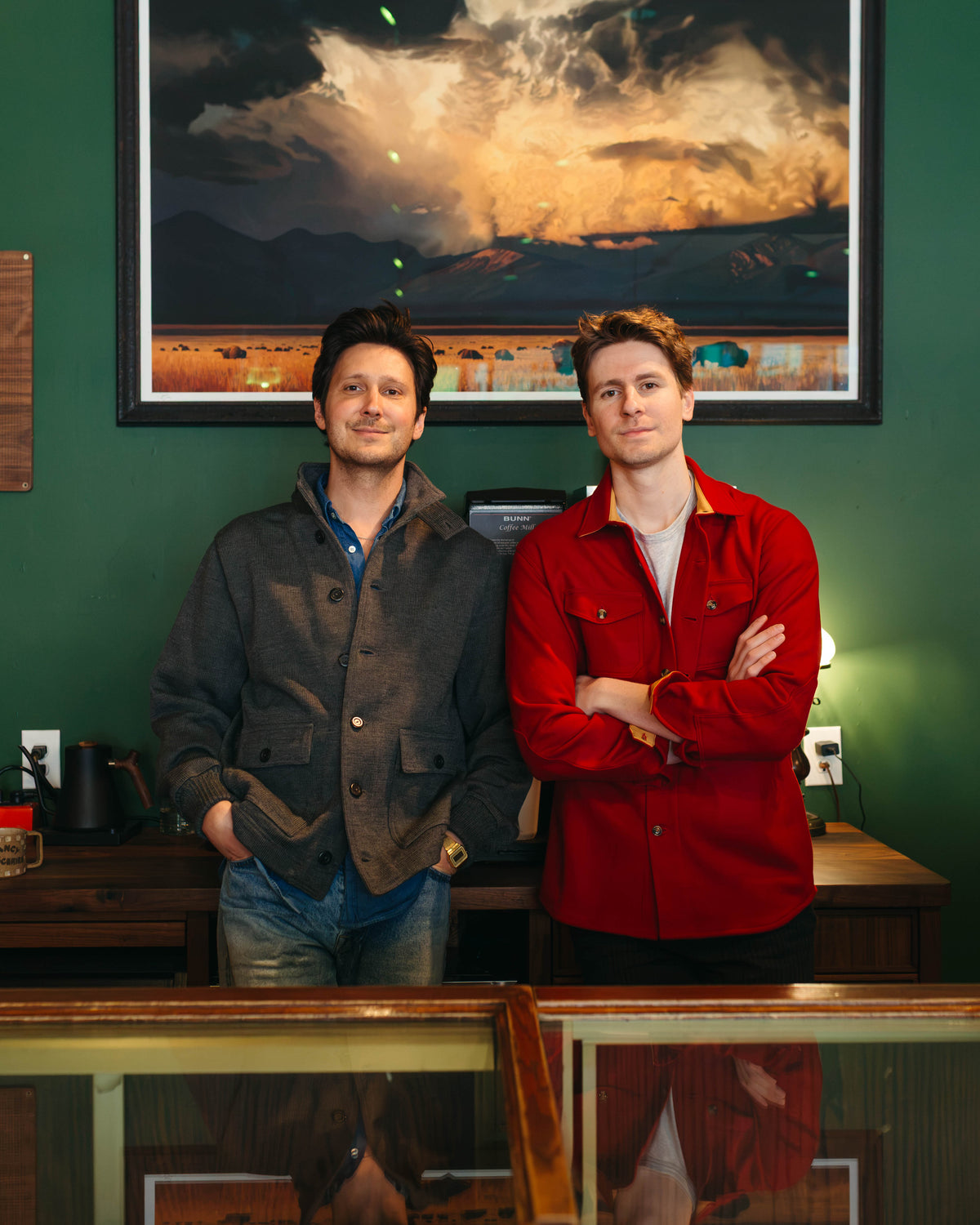 Men standing against green wall wearing Dehen 1920 jackets at Fancy Groceries