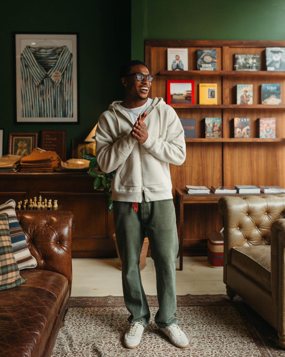Man wearing Wonder Looper Zip Hoodie Double Heavyweight in Oatmeal against a wooden bookcase at Fancy Groceries