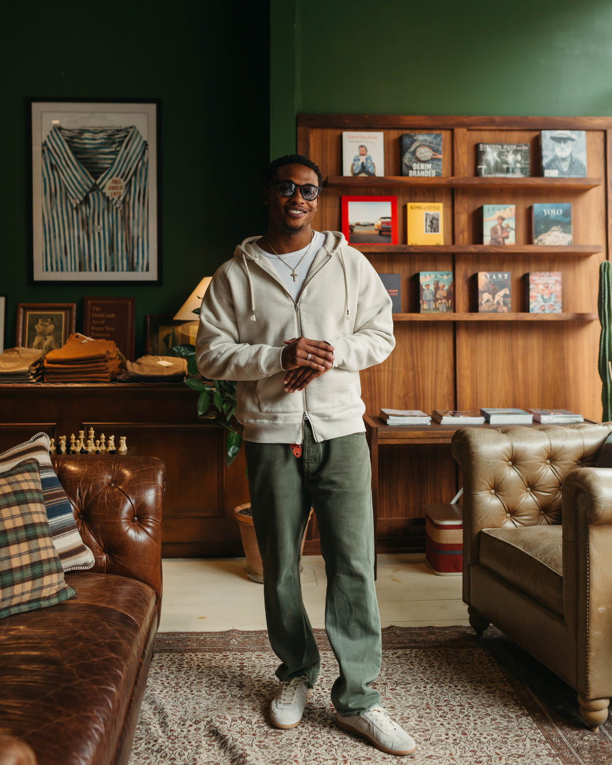 Man wearing zip hoodie against wooden bookcase at Fancy Groceries